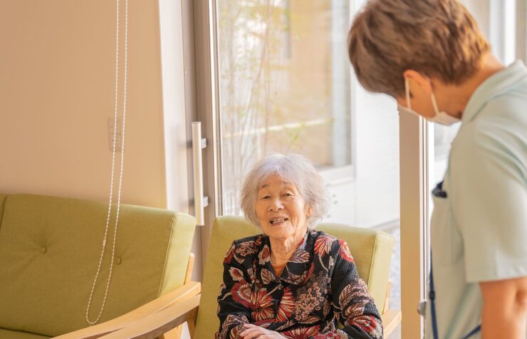 入居者と職員のコミュニケーション風景。窓辺で会話する様子。